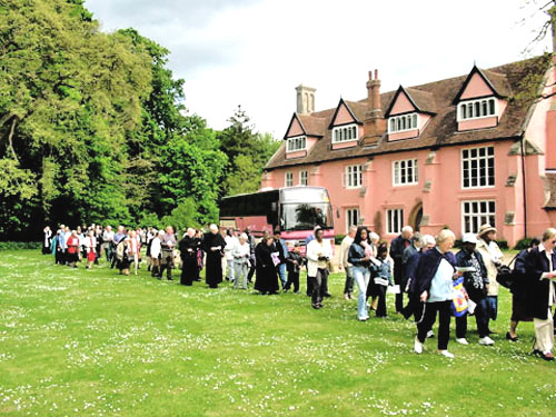A pilgrim group prays in procession at Clare Priory, Suffolk, England